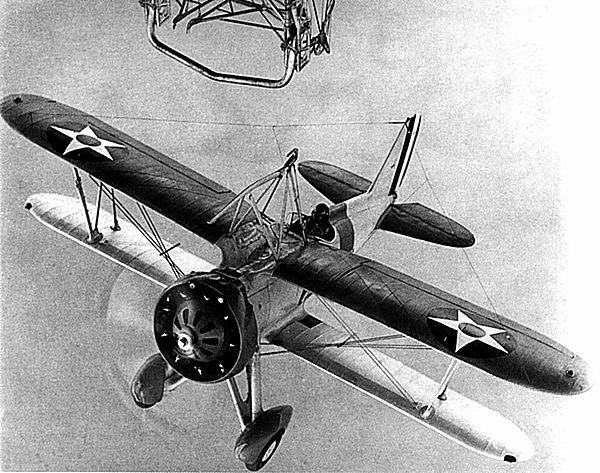 A Curtiss F9C Sparrowhawk hanging by its skyhook from the trapeze under a Navy airship